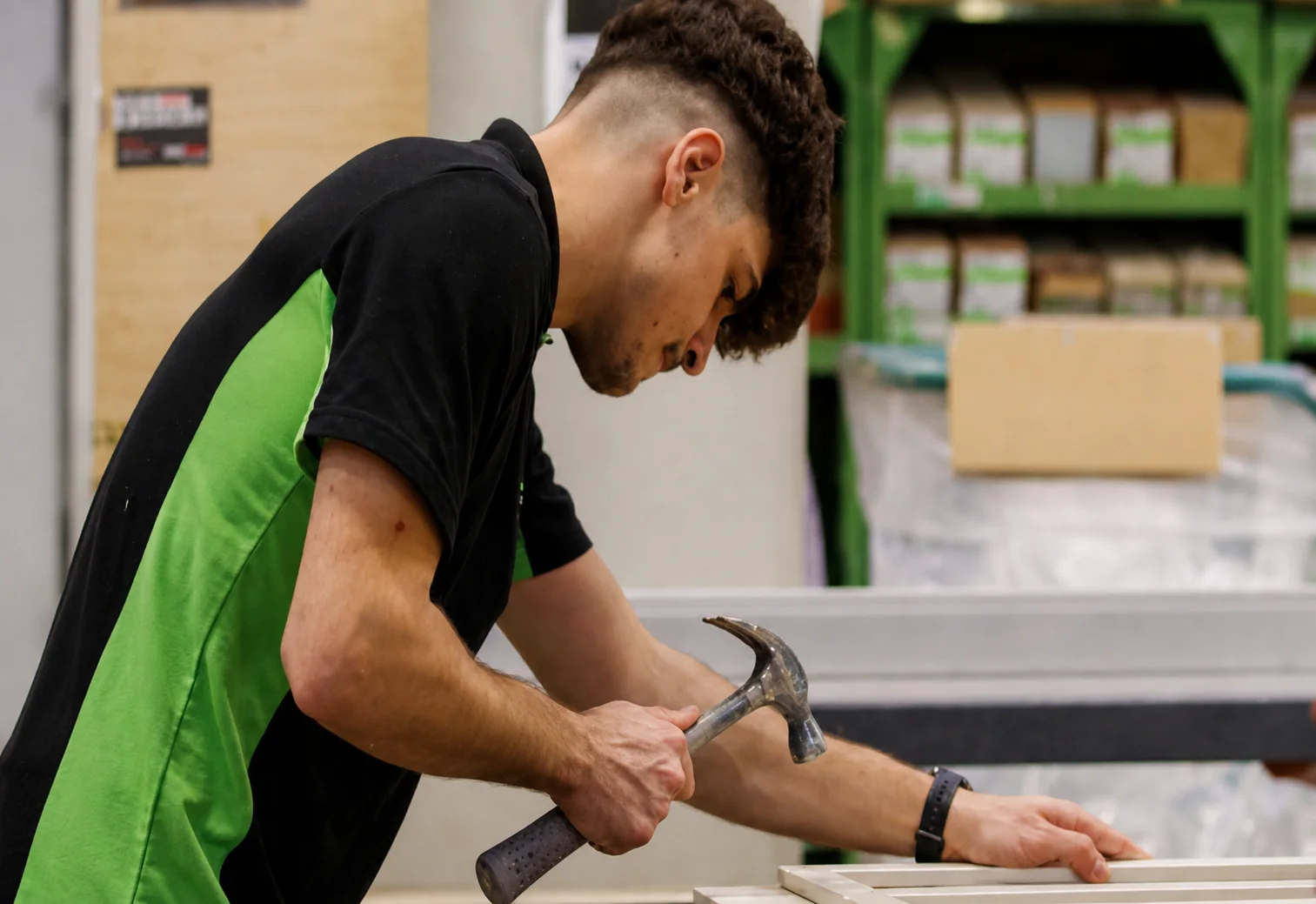 Auszubildender arbeitet mit einem Hammer an einem Werkstück